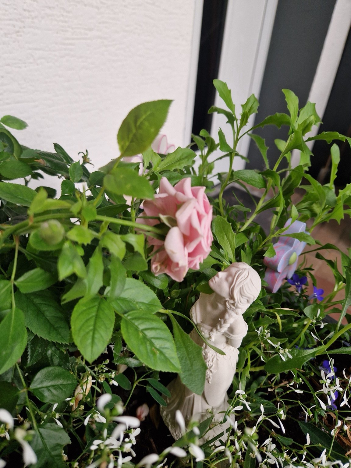 Liebevoll gestaltete Pflanzendekoration mit Figur und Blumen